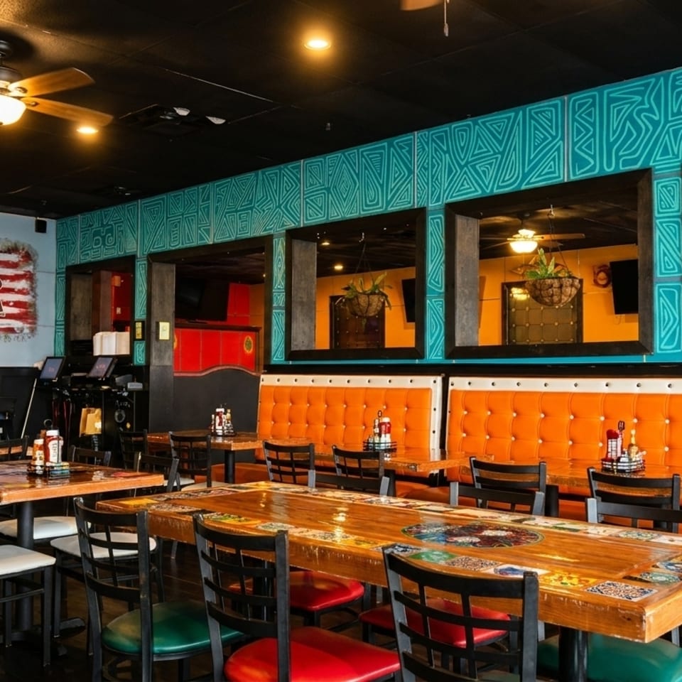 Colorful restaurant interior with wooden tables, orange booths, and a "Vamos USA!" flag mural.